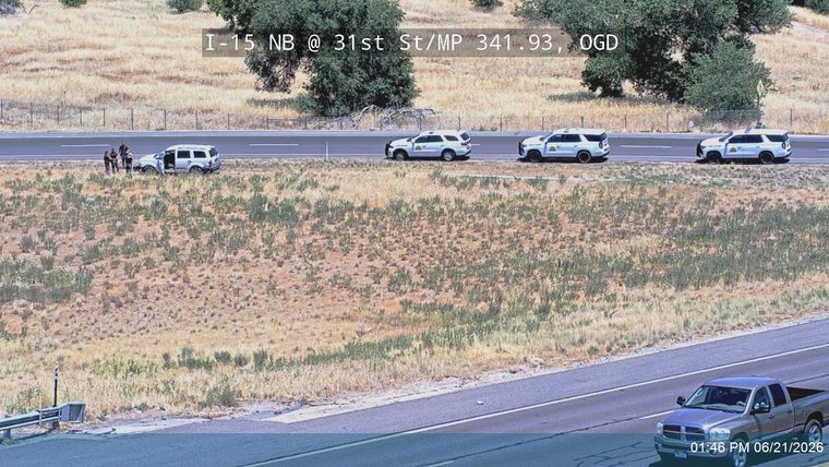 Three police vehicles and a white SUV on the right shoulder