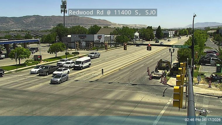 Construction equipment and personnel are present on the roadway, indicating ongoing work.