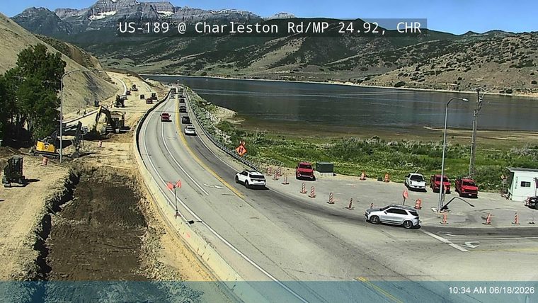 Construction vehicles and workers are present on the roadway, indicating ongoing work.