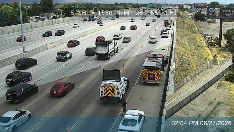Fire truck and a white utility truck with a person standing between them in the right lane