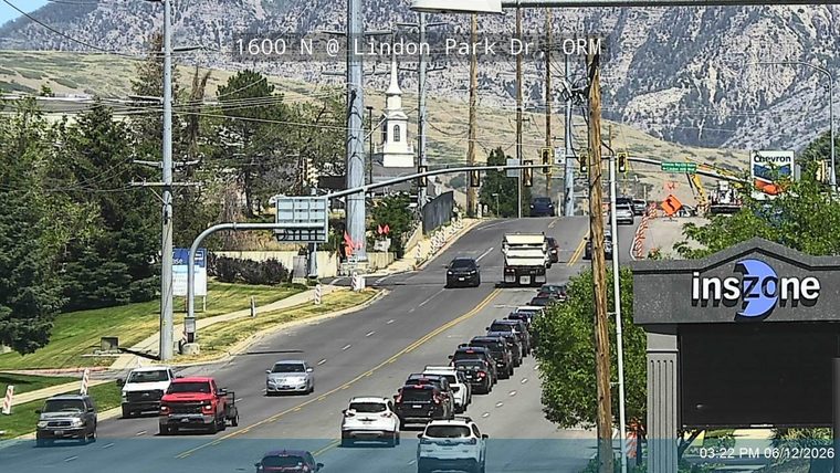 Construction crew and equipment on the road with traffic cones and signs.