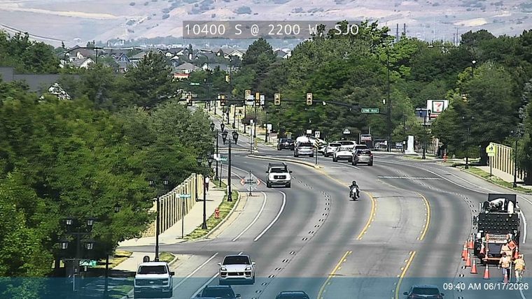 Road work crew with cones and equipment on the right side of the road.