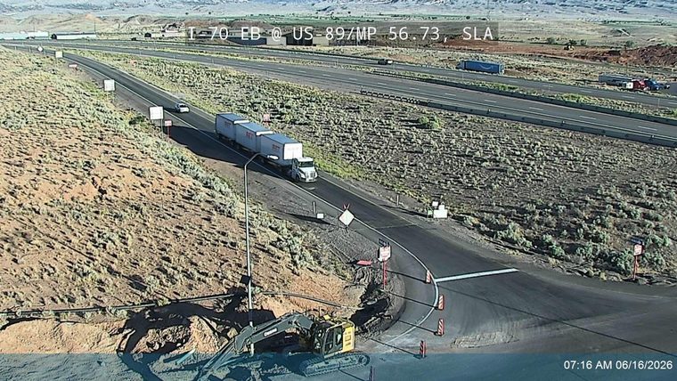 Construction equipment and cones indicate road work or an incident response.