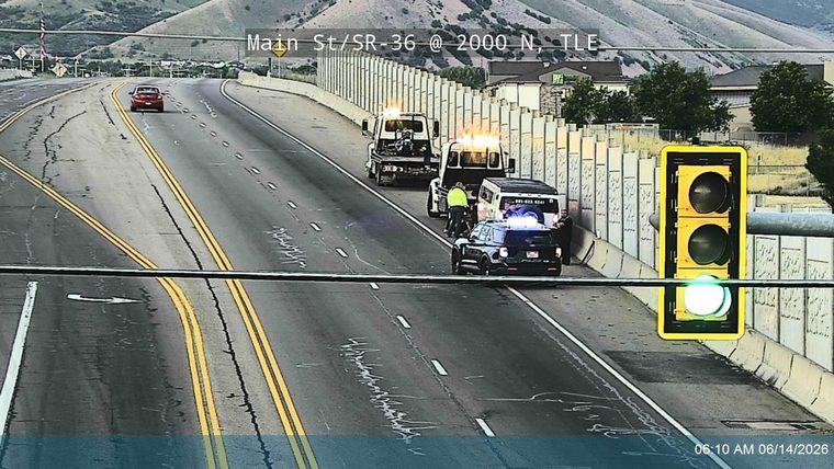 Police and tow trucks on scene with flashing lights assisting a vehicle.