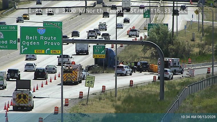 Emergency responders and vehicles at a roadside incident with traffic cones.