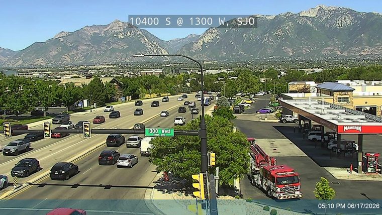 Fire truck is present at a gas station on the side of the road.
