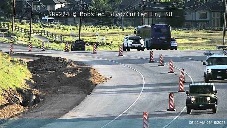 Road construction debris and a damaged culvert are visible on the side of the road.