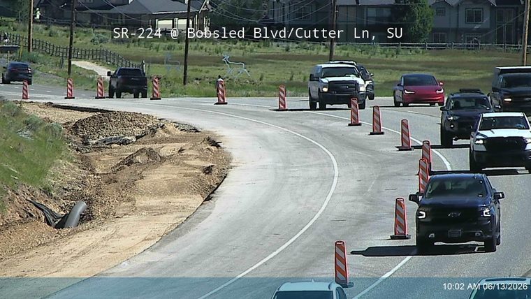 Road construction debris and a large pipe are visible on the side of the road.