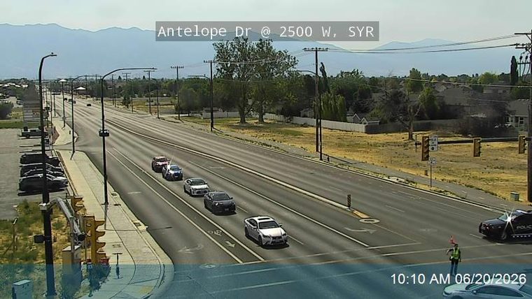 Police car with lights on the right shoulder, and a person directing traffic
