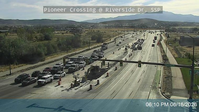 Construction zone with traffic backup and an excavator on the roadway.