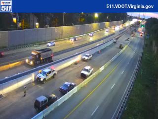 Emergency responders and vehicles are present on the roadway, indicating an incident.