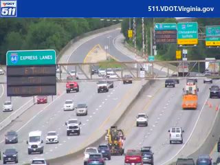 Construction vehicle and cones on highway, likely road work or incident response.