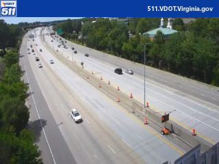 Road work with cones and a vehicle on the shoulder.