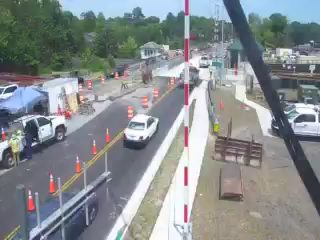 Construction zone with workers and vehicles, traffic control measures in place.