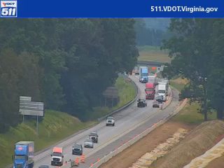 Emergency responders and vehicles are present on the roadway, causing traffic disruption.