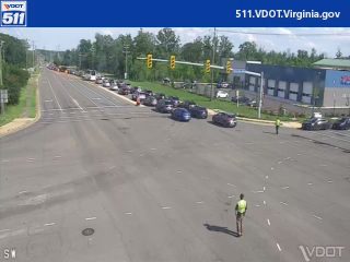 Two individuals in high-visibility vests are present near the intersection.