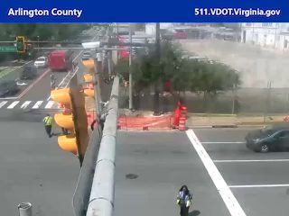 Emergency responders are present at the roadside with cones and barriers.
