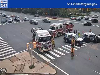 Two fire trucks and two police cars with responders on the roadway
