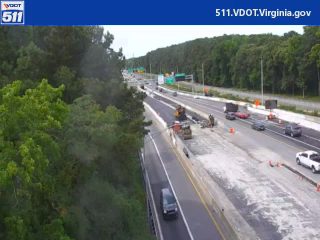 Road construction with workers and equipment visible on the highway.