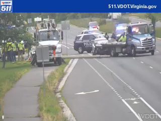 Police car and tow truck with emergency lights on the right shoulder