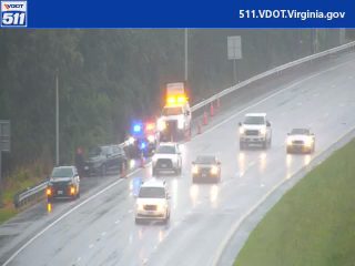 Multiple emergency vehicles with lights on the right shoulder