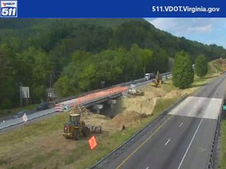 Construction vehicles and equipment are present on the roadway and surrounding area.