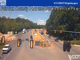 Construction zone with cones and workers present and workers visible on the roadway.