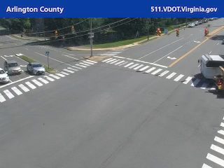 Emergency responders are present at the intersection with cones and vehicles.