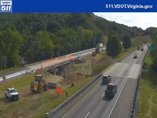 Construction zone with workers and equipment near the roadway.