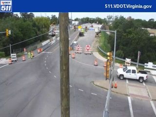 Road work with personnel and equipment present, traffic control in place.