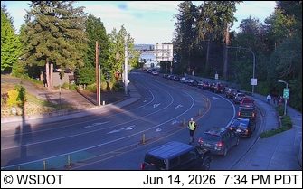Emergency responder directing traffic on a curved roadway with stopped vehicles.