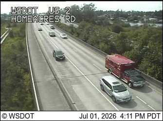 Red and black emergency vehicle with red and blue lights on the right shoulder