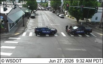 Two police cars with lights on in the intersection