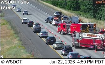 Multiple emergency vehicles and vehicles in lanes with cones and barriers