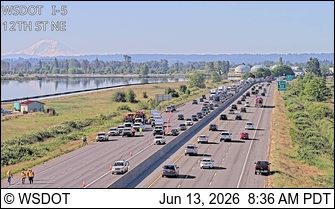 Emergency responders and vehicles are present on the shoulder of the highway.