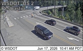 Worker in orange vest directing traffic at intersection.