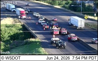 Multiple emergency vehicles and workers in the right lane