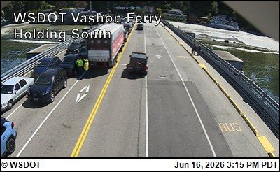 Two people in yellow vests appear to be directing traffic near a large truck.