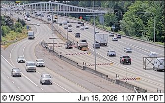 Road work with personnel and equipment on the highway shoulder.