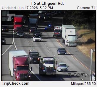 Emergency vehicles, including an ambulance, are present on the highway.