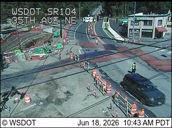 Construction zone with workers and a police officer directing traffic.