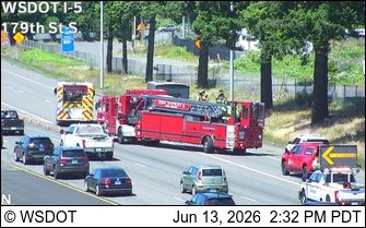 Fire truck and personnel on scene on the highway.