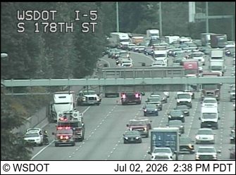 Two fire trucks with lights on in the left lanes