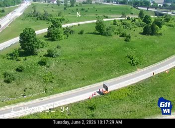 Emergency responders and cones on the side of the road near a truck.