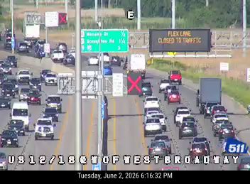 Emergency responder vehicle with flashing lights on the right shoulder, traffic stopped.