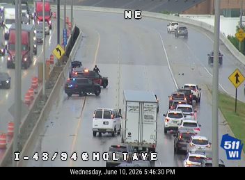 Police and emergency vehicles on the highway with traffic stopped.