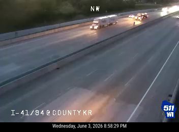 Emergency vehicles are stopped on the highway, possibly responding to an incident.