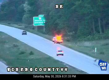 Vehicle fire on the highway with flames visible.