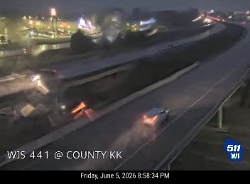 Vehicle appears to have crashed off the roadway, with debris and lights visible.