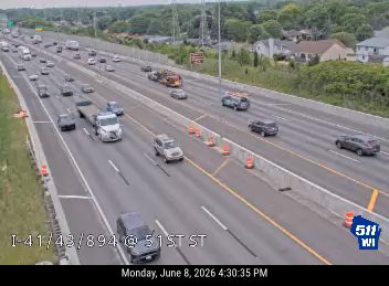 Emergency cones and barriers are set up on the highway, indicating a possible incident.